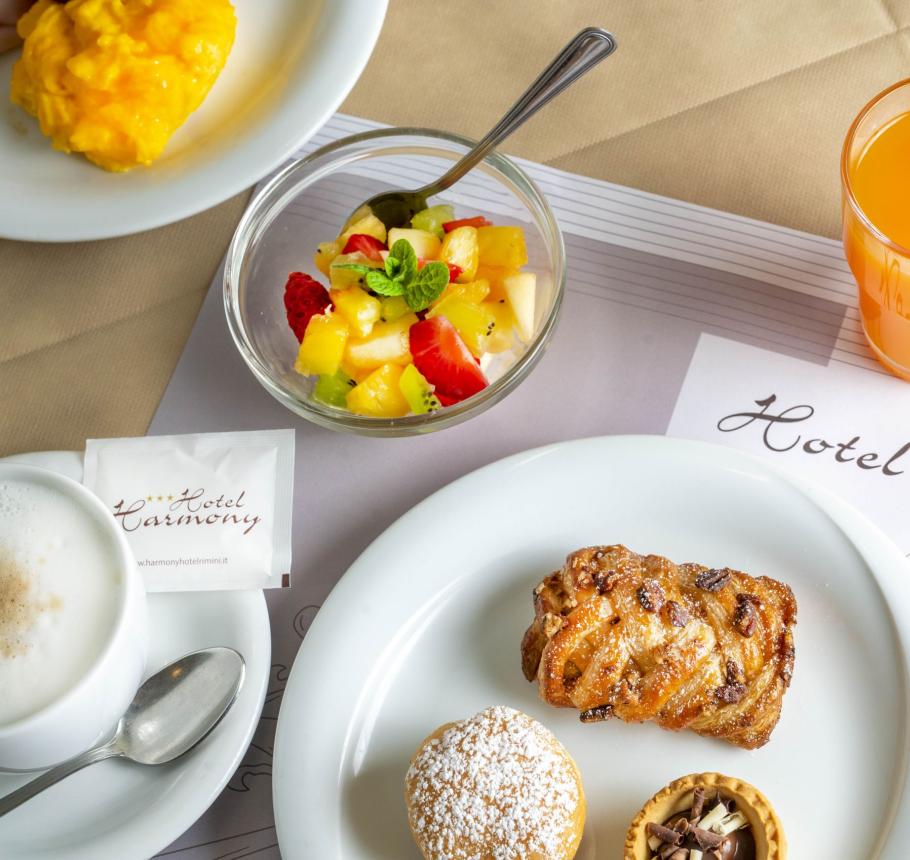 Elegant breakfast with pastries, fresh fruit, and orange juice.